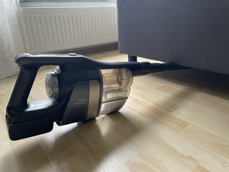 Philips Aquatrio 9000 Cordless bei der Reinigung unter einem Möbel